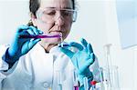 Scientist pouring liquid into petri dish