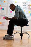 Man sitting on stool with digital tablet