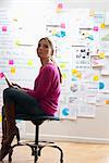 Woman sitting on stool with digital tablet