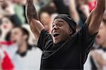 Man at sports game with arms raised