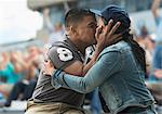 Couple kissing at sports game