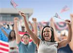 Excited woman waving american flags at rally