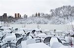 Tables and chairs in snowy urban park