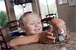 Boy putting savings in glass jar