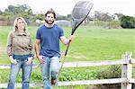 Couple leaning on wooden fence