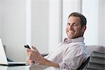 Businessman using cell phone at desk