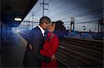 Couple kissing at train station