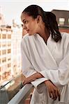 Woman wearing bathrobe on balcony