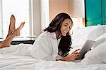 Woman in bathrobe using tablet computer