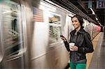 Woman using cell phone at subway station