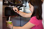 Girl pouring cup of frozen yogurt