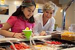 Girl putting toppings on frozen yogurt