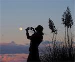 Woman taking picture of moon