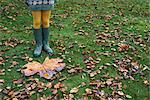 Girl standing by large autumn leaf