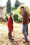 Father and son walking in autumn leaves