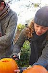 Children carving pumpkins together outdoors