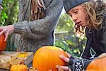 Children carving pumpkins together outdoors
