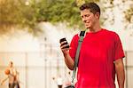 Man using cell phone on basketball court