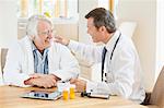 Doctor talking to older patient at house call