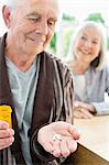 Older man with handful of pills