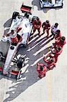 Racing team surrounding racer on track