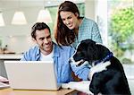 Couple petting dog at table