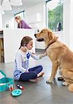 Girl playing doctor with dog in kitchen