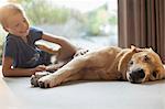 Smiling boy petting dog in living room