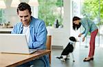 Man using laptop at kitchen table