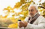 Older man using cell phone outdoors