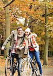 Couple riding bicycles together in park