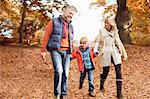Older couple walking with grandson in park