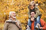 Three generations of men smiling in park