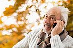 Older man talking on cell phone in park