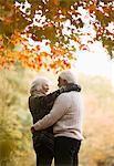 Older couple hugging in park