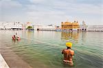 Sikh pilgrims bathing in Nectar Pond at Golden Temple in Amritsar, Punjab, India