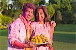 Portrait of a couple holding a plate of sweets on Holi