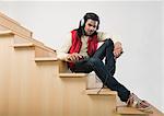 Man listening to an MP3 player on a staircase