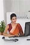 Businesswoman working on a desktop PC in an office