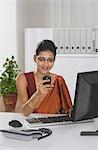 Businesswoman text messaging on a mobile phone