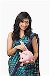 Woman inserting money into a piggybank