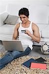 Man doing online shopping with a laptop