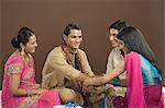 Woman tying rakhi on the wrist of her brother