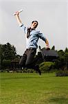 Businessman jumping in a park