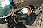 Businessman sitting in a car and talking on a mobile phone