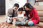 Girl playing Jenga with her parents