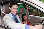 Portrait of a businessman driving a car with his daughter