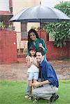 Family enjoying in rain in a park