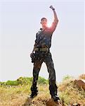 Soldier standing in a field celebrating his success