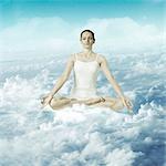 Woman meditating over the clouds